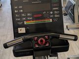 many tread machines in the gym with people in the background