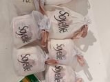 five bags of toilet paper with the names of the bride and groom on them