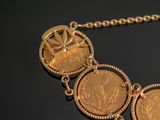 a gold necklace with three coins attached to it