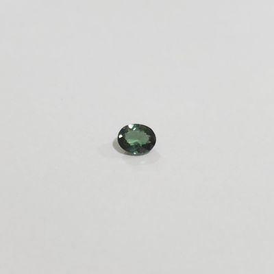 a green tourmaline gems on a white surface