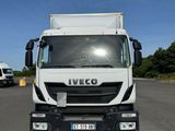 un camion blanc garé sur le bord de la route