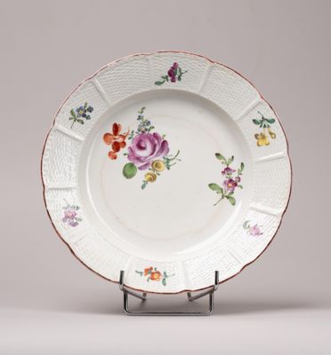 un gros plan d'une assiette décorée de fleurs, posée sur un support