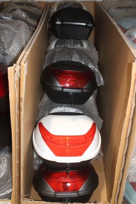 trois cartons contenant des casques, posés par terre