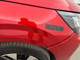 a close up of a red car with a sticker on it