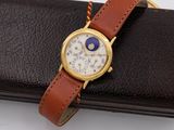 a gold watch with a brown leather band and a blue eye