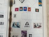 an open book with stamps on it on a table
