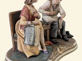 a figurine of a man and a woman sitting on a chair