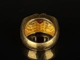 an image of a gold ring with a red stone in the center