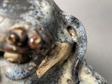 a close up of a statue of a dog with a bone in it ' s mouth
