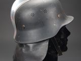 an old helmet on a mannequin head on a gray background