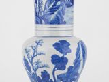 un vase bleu et blanc posé sur une surface blanche