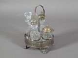 a silver plate with a glass bottle and a spoon on it