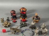 Plusieurs types de figurines asiatiques sont exposées sur un support gris.