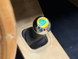 a close up of a car ' s gear lever with a sticker on it