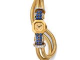 un gros plan d'une montre en or sertie de pierres bleues