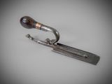 an image of a small metal object with a handle on a white surface