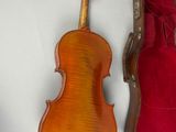 violin and case sitting on a white surface next to each other