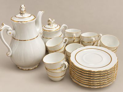 un service à thé blanc et or avec tasses et soucoupes