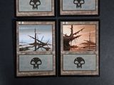 four cards with different designs on them on a black surface