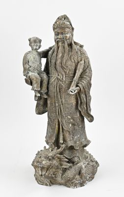 an old statue of a man holding a child on a rock