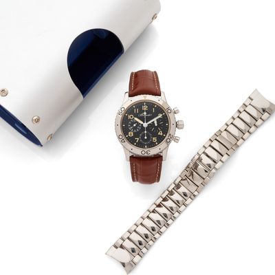 une montre posée à côté d'un portefeuille sur une table
