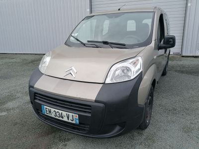 une petite camionnette garée devant un immeuble