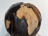 a sculpture of a brown and black globe on top of a white shelf