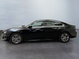 the black car is parked in a large room with a gray floor
