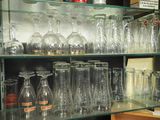 a glass shelf with many glasses on it