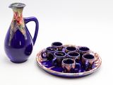 a blue pitcher and a plate with cups on it