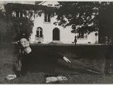 photographie en noir et blanc d'une femme allongée sur l'herbe devant un immeuble