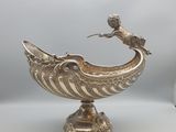 un bol en argent surmonté d'un oiseau