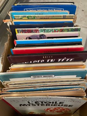 beaucoup de livres dans une boîte posée sur le sol