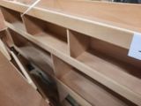 a wooden shelf with a sign on it in a store