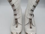 pair of white leather boots with silver metal heelings on a white surface
