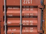 a red shipping container that is sitting on the side of the road