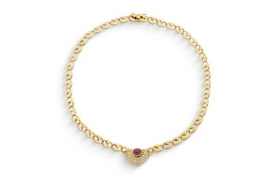 un bracelet en or orné d'un pendentif en forme de cœur et d'une pierre rouge