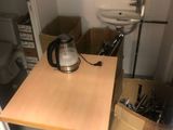 a small table with a kettle on it in a small room