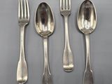 four silver spoons and a fork on a gray surface