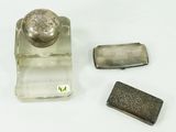 three silver objects on a white surface next to each other