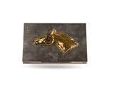 a close up of a gold horse head on a black box