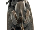 bronze figurine of a dog with a hat and a leash