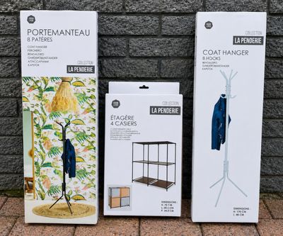 trois cartons de cintres posés sur un sol en briques, à côté d'un mur en briques