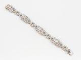 a close up of a diamond bracelet on a white surface