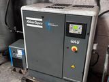 un petit compresseur d'air posé sur une palette dans un garage