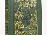 un vieux livre à la couverture verte, ornée de lettres dorées
