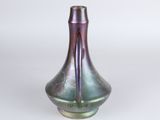 a purple and green vase sitting on a white surface