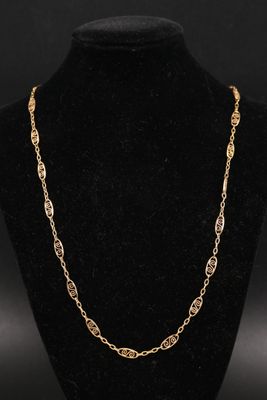 un collier plaqué or dont la chaîne a été placée sur un mannequin