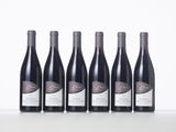 six bottles of wine are lined up on a table