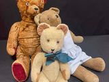 three teddy bears sitting next to each other on a table